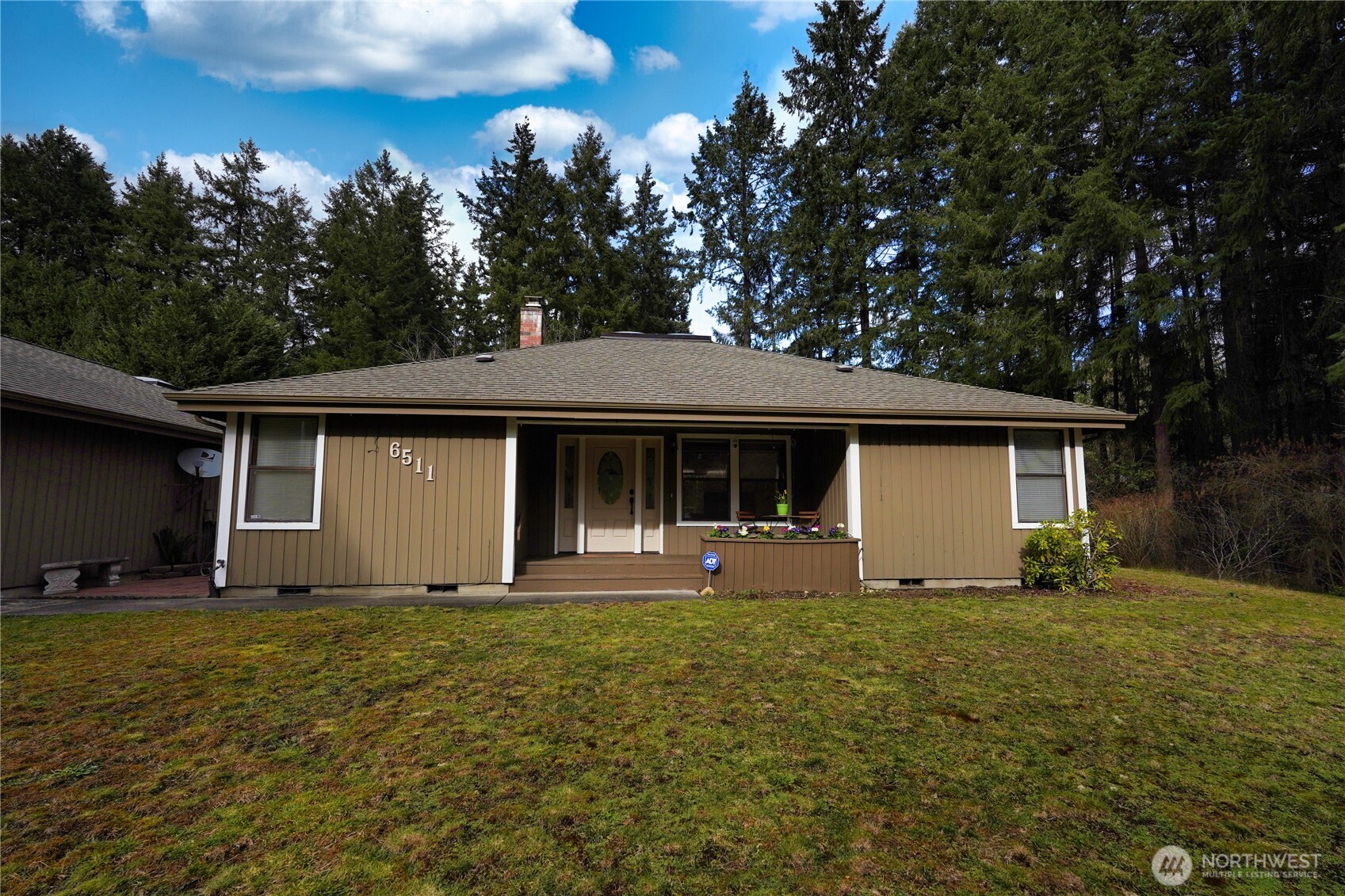6511 255th St Court East Graham, WA 98338 - Photo 2 of 20 a front view of house with yard and trees in the background