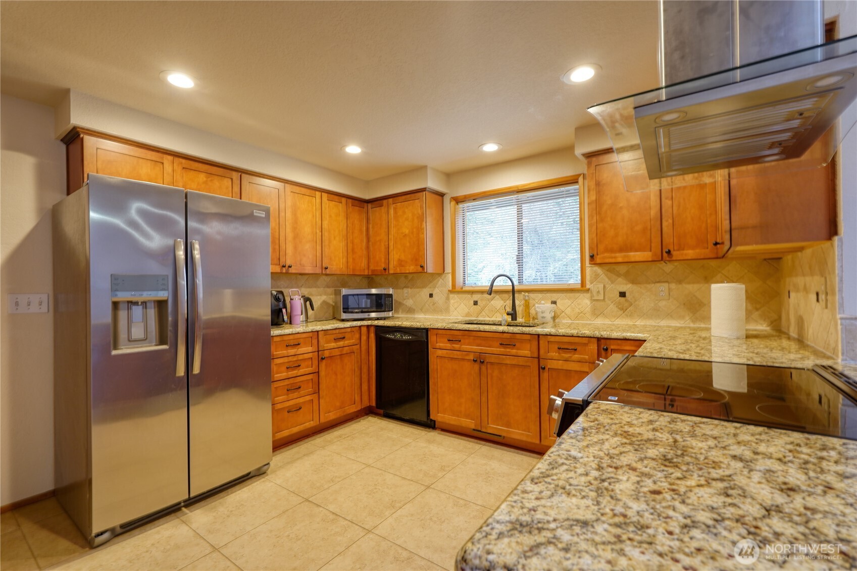 6511 255th St Court East Graham, WA 98338 - Photo 8 of 20 a large kitchen with granite countertop a large counter top stainless steel appliances and cabinets
