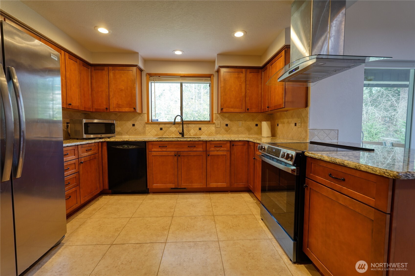 6511 255th St Court East Graham, WA 98338 - Photo 9 of 20 a kitchen with stainless steel appliances granite countertop a sink stove and refrigerator