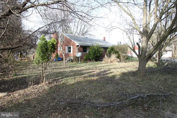a view of a house with a yard and large trees