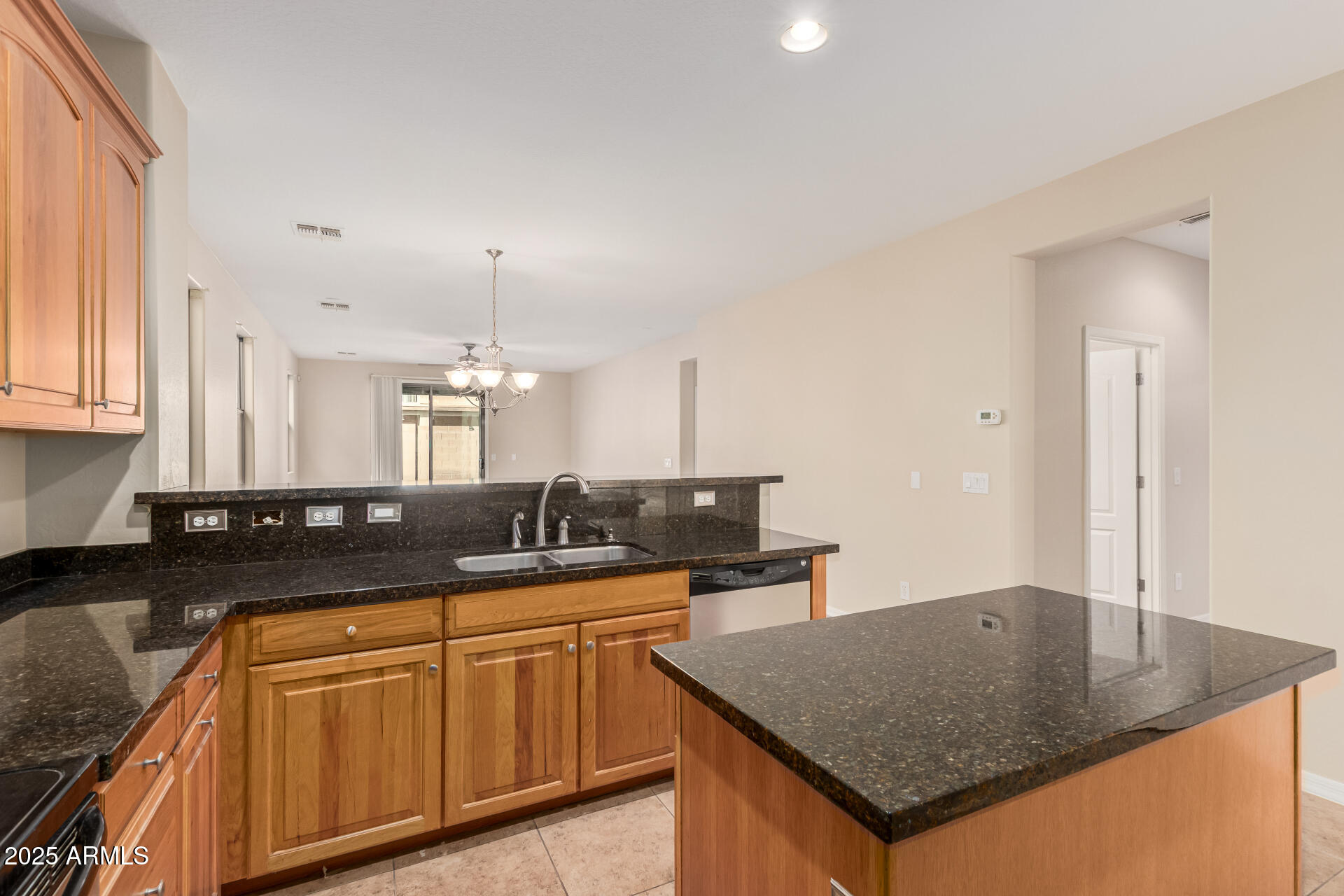 2530 West Gaby Road Phoenix, AZ 85041 - Photo 6 of 30 a kitchen with granite countertop a sink a stove counter space and cabinets