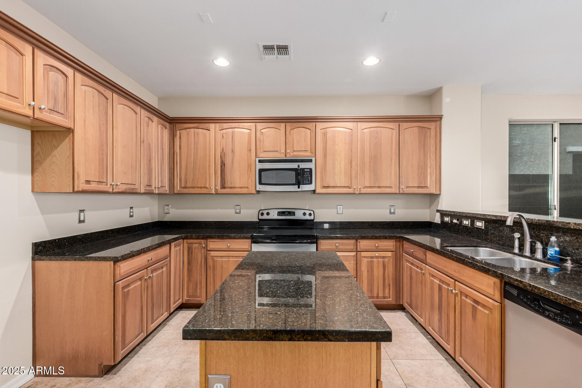 2530 West Gaby Road Phoenix, AZ 85041 - Photo 8 of 30 a kitchen with stainless steel appliances granite countertop a stove sink microwave and window