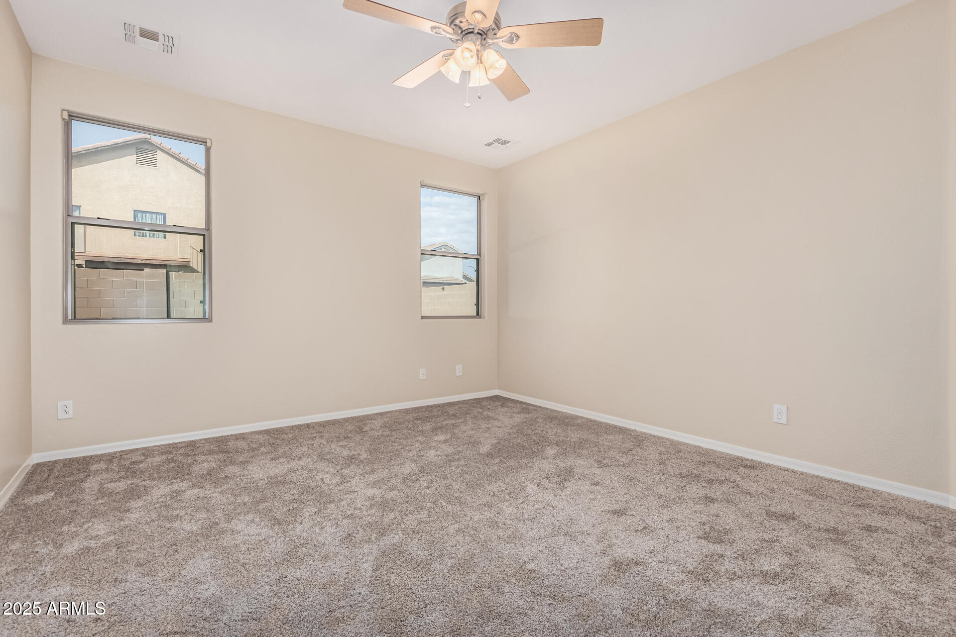 2530 West Gaby Road Phoenix, AZ 85041 - Photo 9 of 30 an empty room with windows and fan