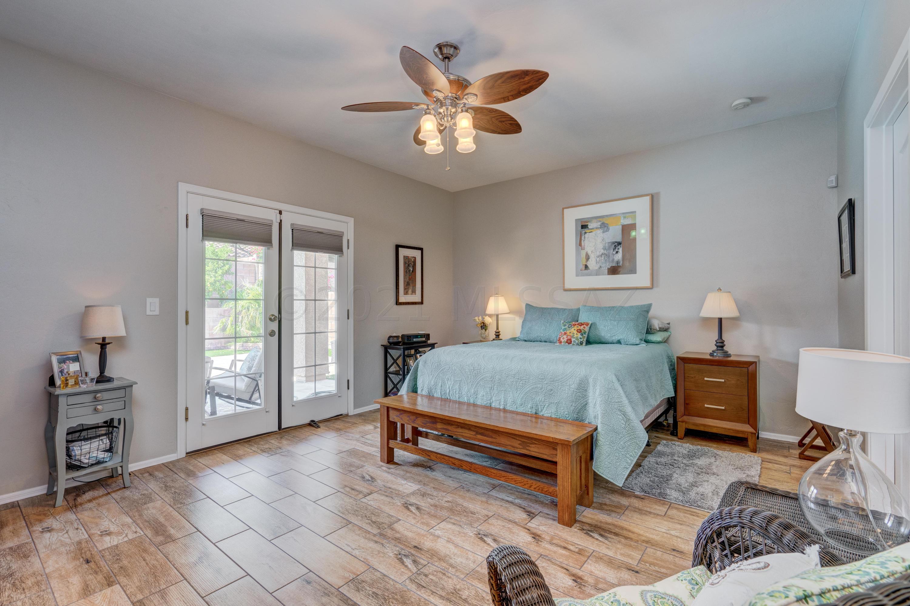 3639 East Northern Dancer Road Tucson, AZ 85739 - Photo 23 of 48 a spacious bedroom with a bed and a chandelier