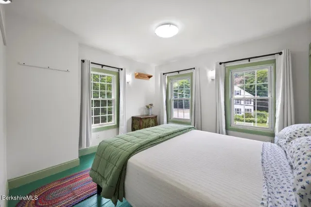 a bedroom with a bed and a painting on the wall