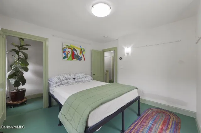 a bedroom with a bed and painting on the wall