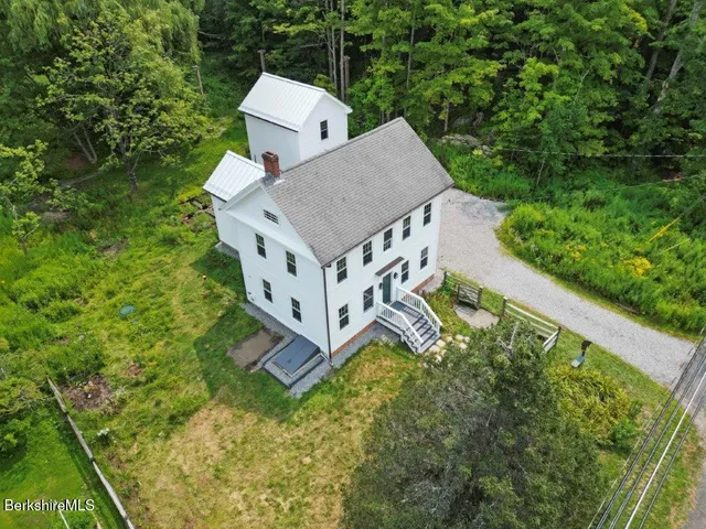 an aerial view of a house with garden space and street view