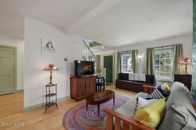 a living room with furniture a flat screen tv and a window