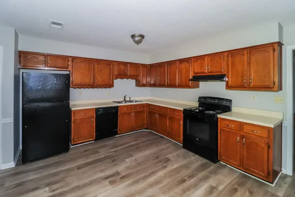 a kitchen with granite countertop a sink cabinets and stainless steel appliances