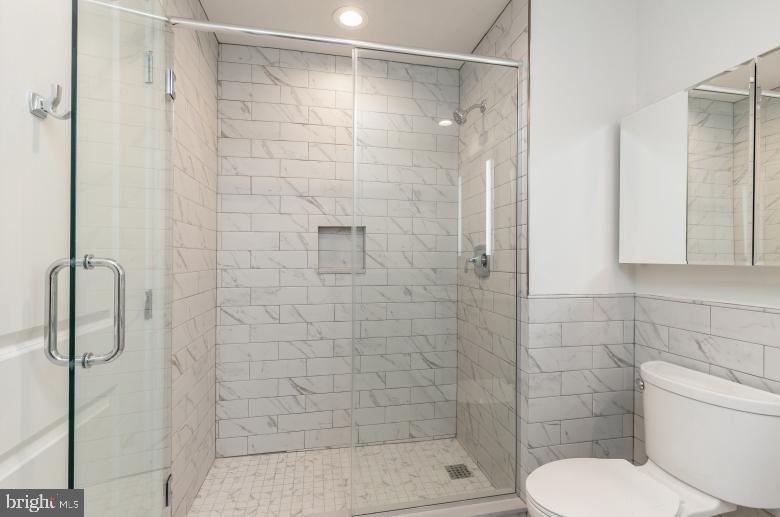 139-59 North 23rd Street, Unit 117 Philadelphia, PA 19103 - Photo 12 of 28 a bathroom with a shower and toilet