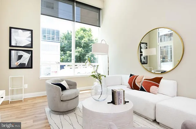 a living room with furniture kitchen view and a potted plant