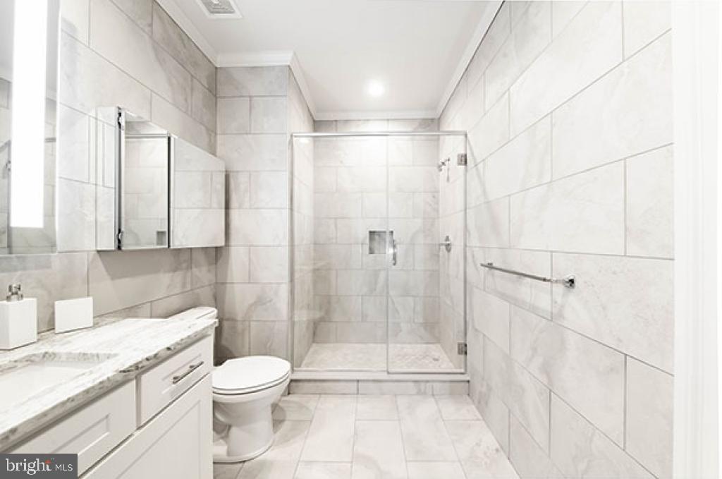 139-59 North 23rd Street, Unit 117 Philadelphia, PA 19103 - Photo 23 of 28 a bathroom with a granite countertop sink a toilet and shower