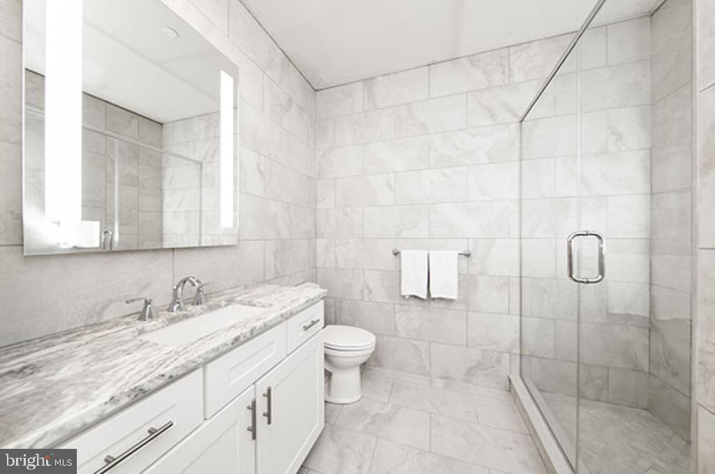 139-59 North 23rd Street, Unit 117 Philadelphia, PA 19103 - Photo 8 of 28 a bathroom with a granite countertop sink a toilet and shower