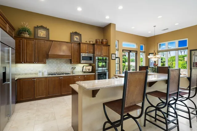 a backyard of a house with table and chairs under an umbrella