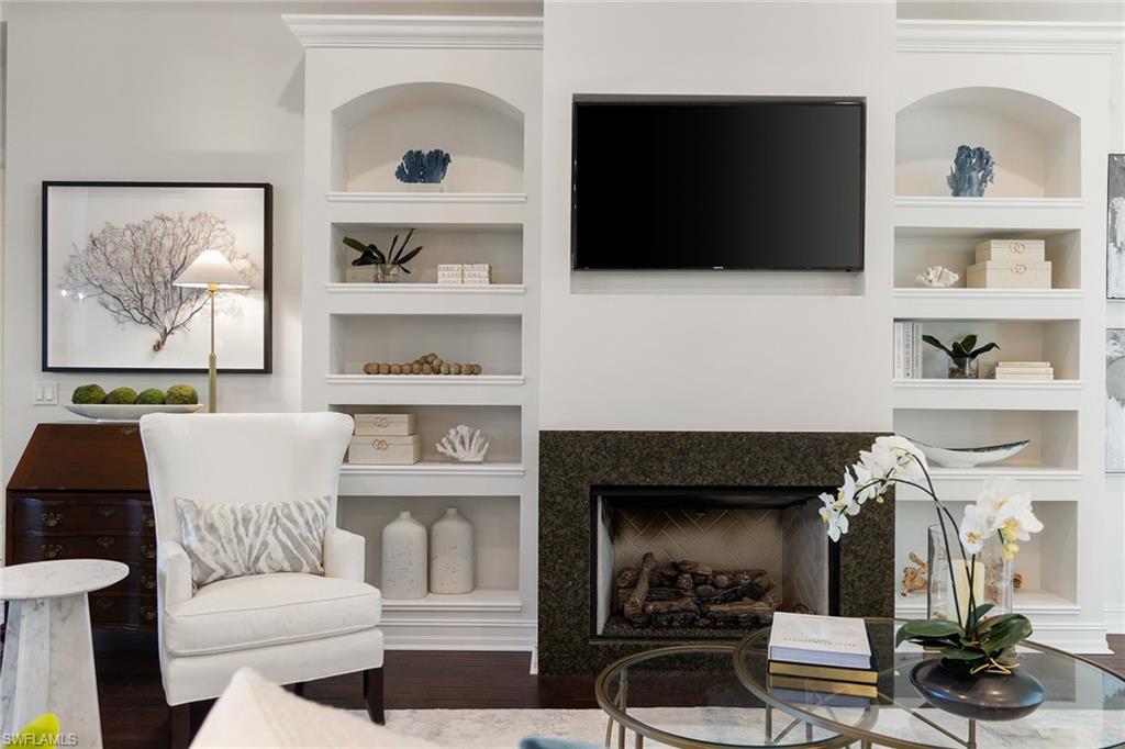 642 Bougainvillea Road Naples, FL 34102 - Photo 11 of 50 Living room with built in features, wood finished floors, and a fireplace