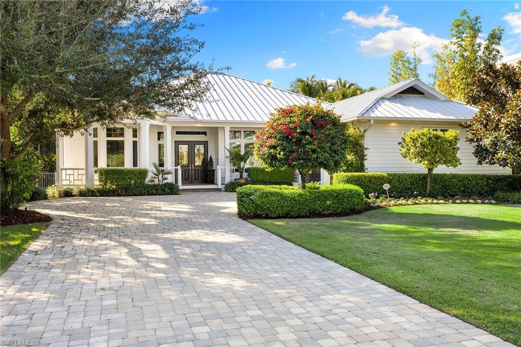 642 Bougainvillea Road Naples, FL 34102 - Photo 2 of 50 View of front facade featuring a metal roof, french doors, a porch, and decorative driveway