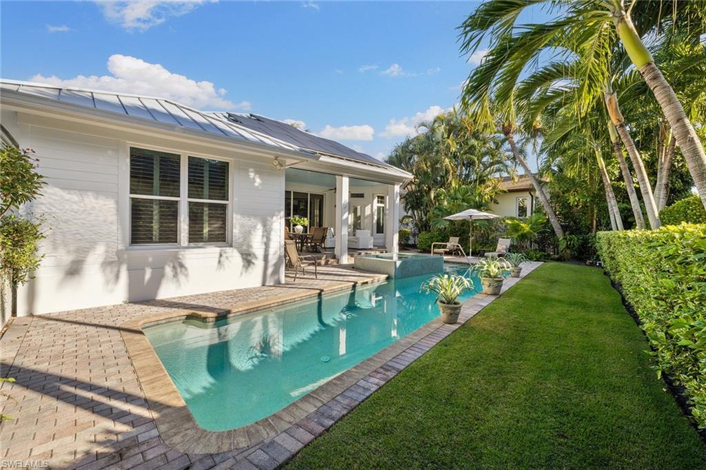 642 Bougainvillea Road Naples, FL 34102 - Photo 23 of 50 Swimming pool featuring a patio and a lawn