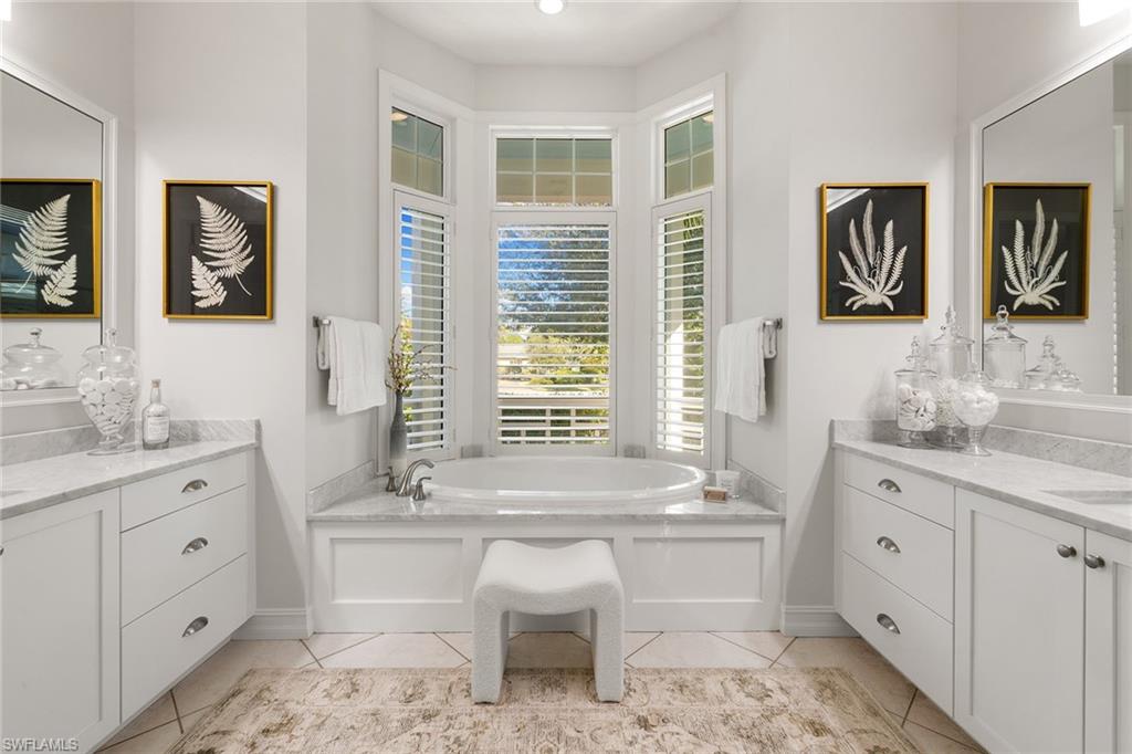 642 Bougainvillea Road Naples, FL 34102 - Photo 27 of 50 Bathroom featuring a garden tub, vanity, and light tile patterned flooring