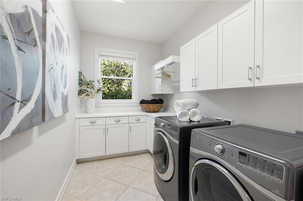 642 Bougainvillea Road Naples, FL 34102 - Photo 40 of 50 Laundry room featuring light tile patterned flooring, cabinet space, and washing machine and clothes dryer