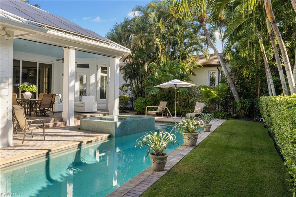 642 Bougainvillea Road Naples, FL 34102 - Photo 46 of 50 View of pool with outdoor dining area, a patio, a yard, and a pool with connected hot tub