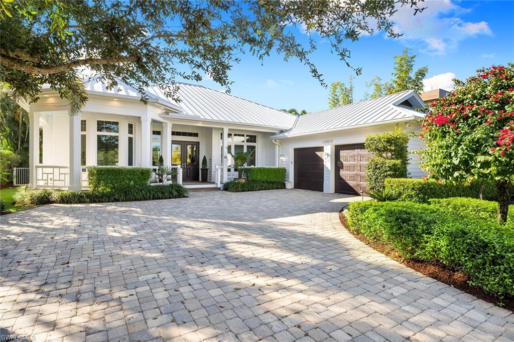 642 Bougainvillea Road Naples, FL 34102 - Photo 47 of 50 View of front of house featuring a metal roof, decorative driveway, a porch, and a standing seam roof