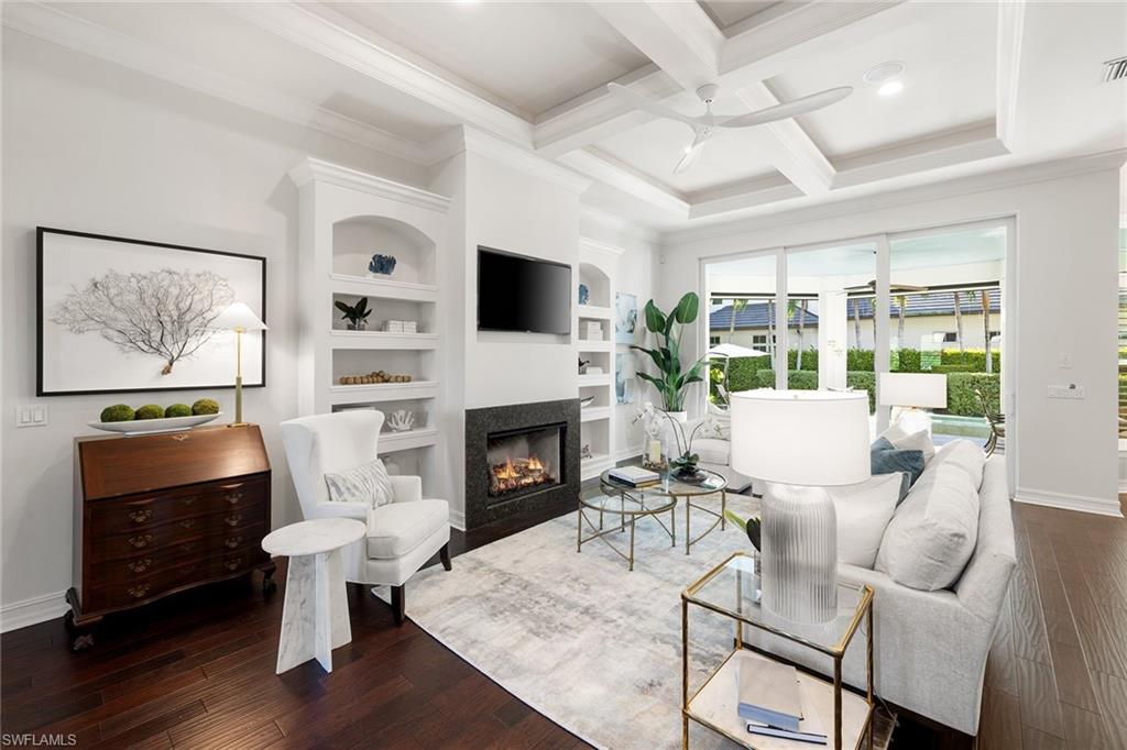 642 Bougainvillea Road Naples, FL 34102 - Photo 8 of 50 Living room featuring coffered ceiling, built in features, crown molding, beamed ceiling, and hardwood / wood-style floors