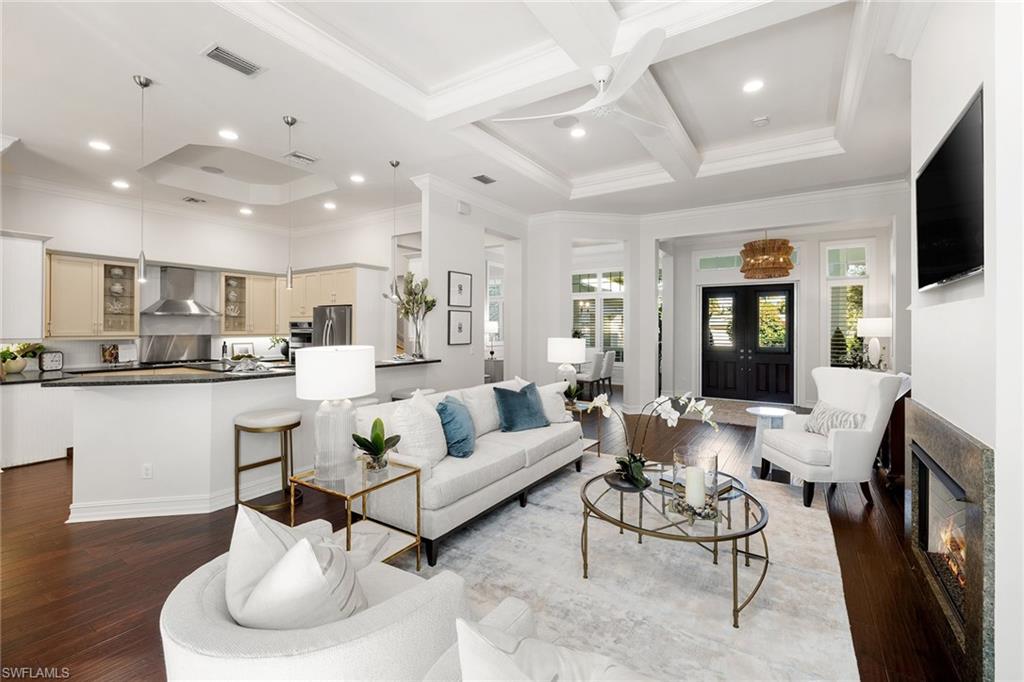 642 Bougainvillea Road Naples, FL 34102 - Photo 10 of 50 Living area with crown molding, coffered ceiling, a fireplace, beam ceiling, and dark wood-type flooring