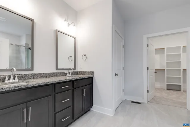 a bathroom with a granite countertop sink double and mirror
