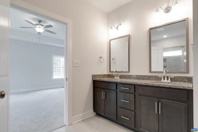 a bathroom with a granite countertop sink a large mirror and a