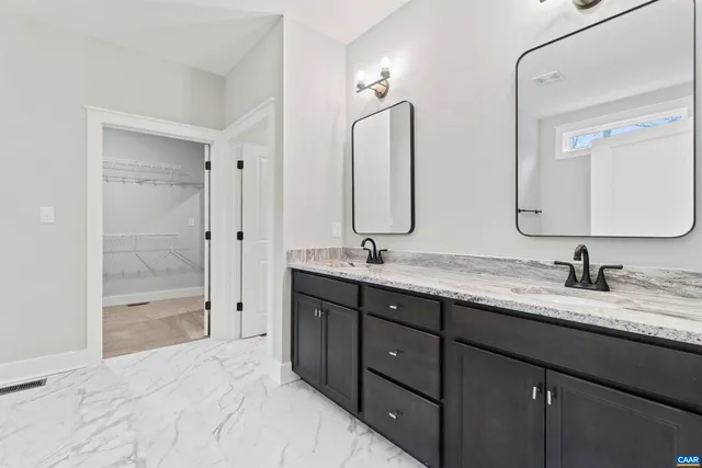 a bathroom with double vanity sinks and a shower