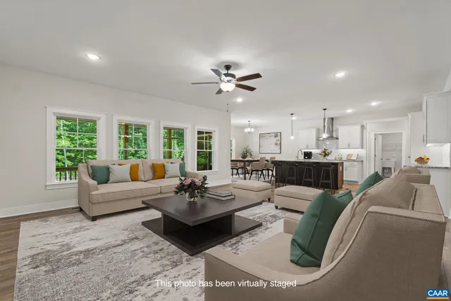 a living room with furniture kitchen view and a chandelier