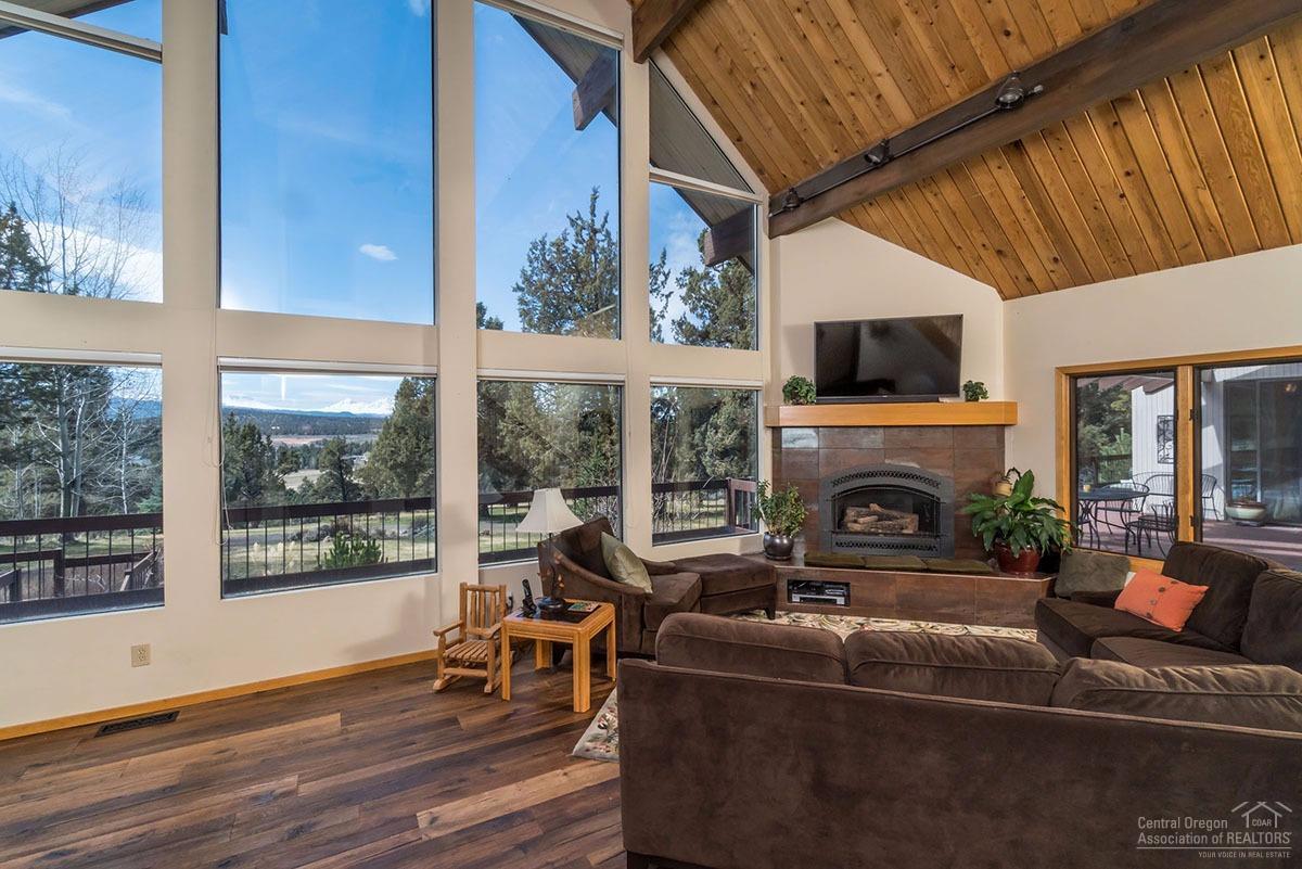 20135 Tumalo Road Bend, OR 97703 - Photo 5 of 24 a living room with furniture a fireplace and a floor to ceiling window