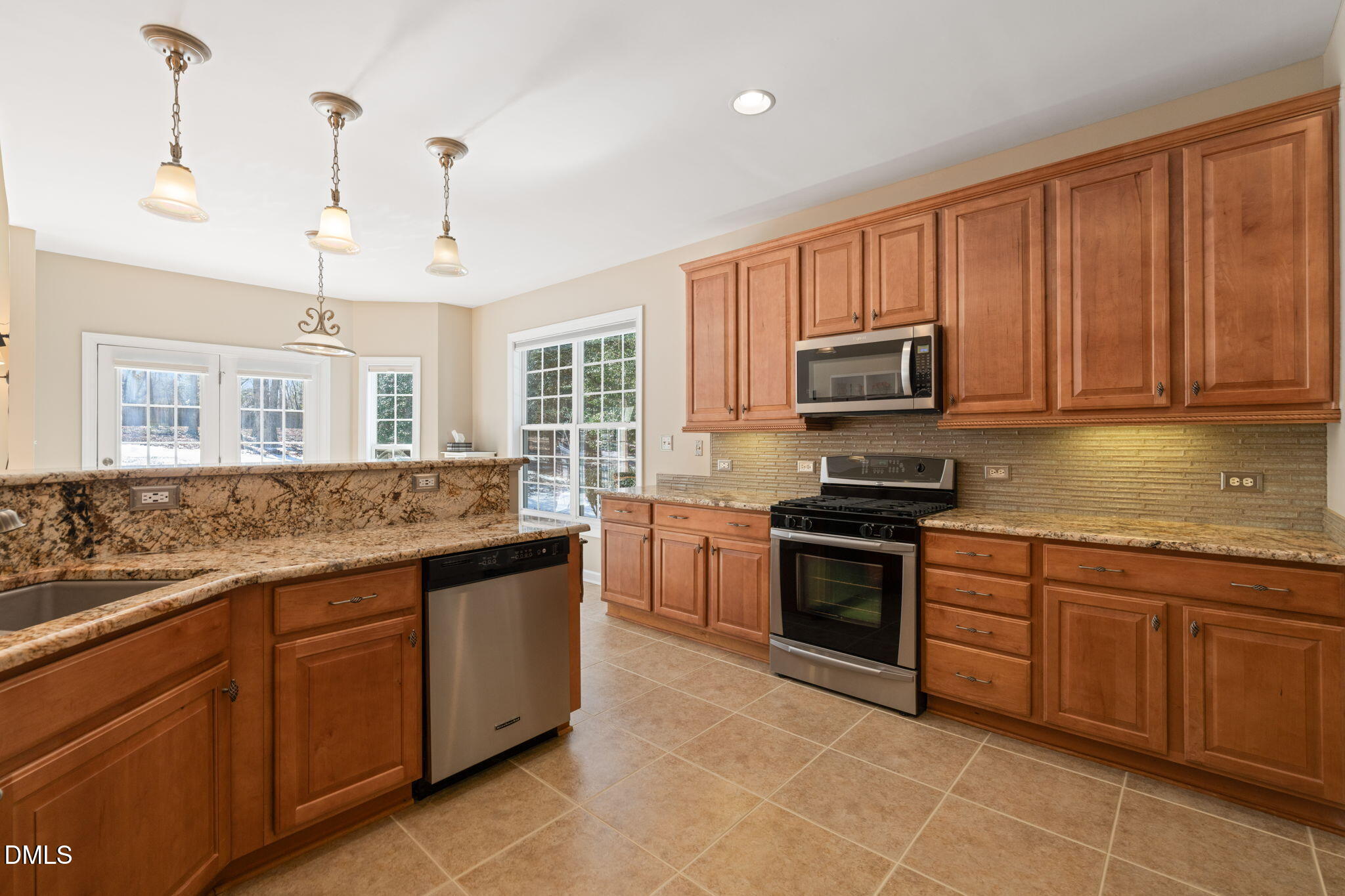 1009 Hidden River Court Raleigh, NC 27614 - Photo 10 of 40 a kitchen with stainless steel appliances granite countertop a stove sink and microwave