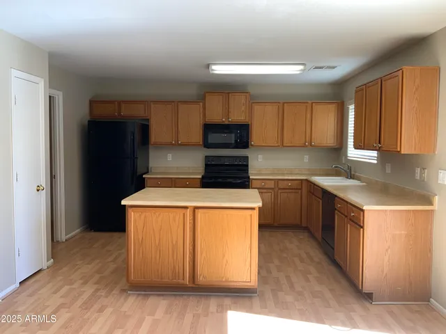a kitchen with a refrigerator a sink and wooden cabinets