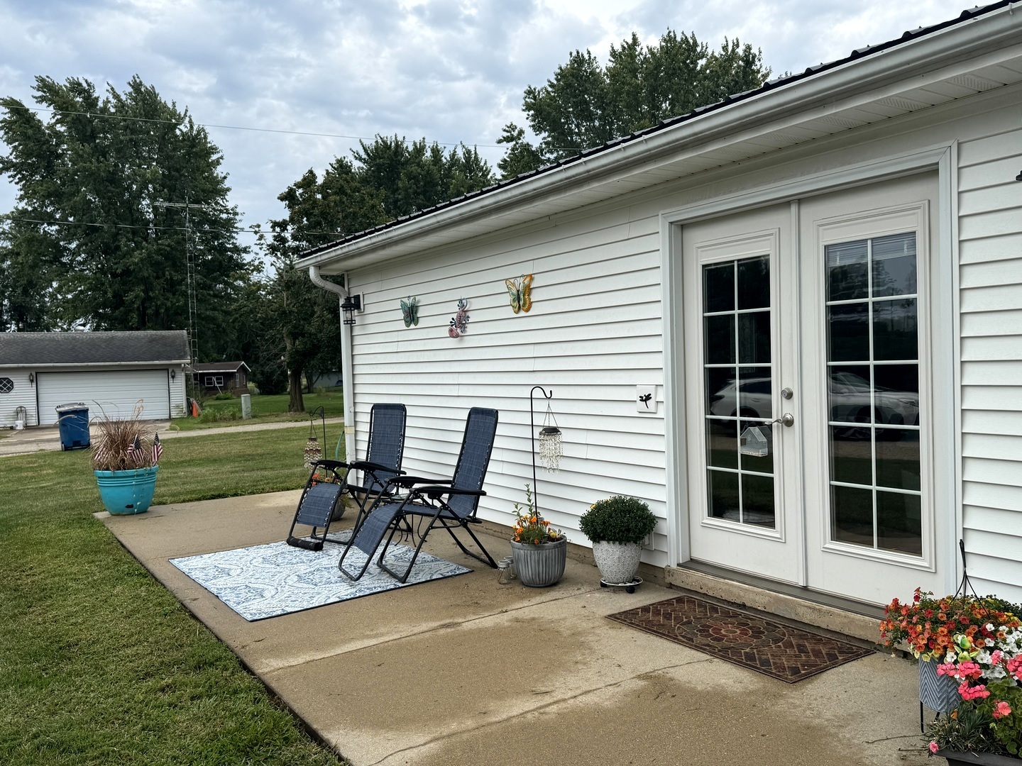 202 Front Street Malden, IL 61337 - Photo 3 of 17 a view of a patio with table and chairs with wooden fence and plants