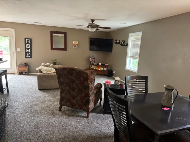a living room with furniture a flat screen tv and a window
