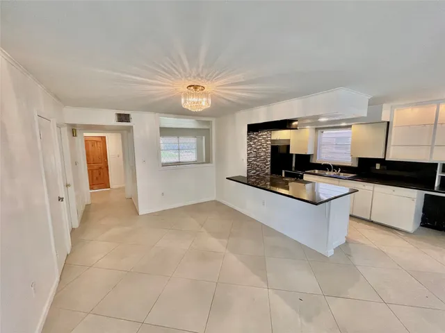 a large kitchen with stainless steel appliances kitchen island granite countertop a sink and cabinets