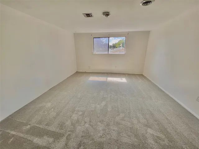 en empty room with window and ceiling fan