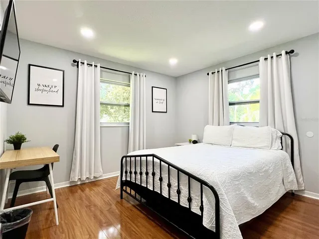a bedroom with a bed and wooden floor