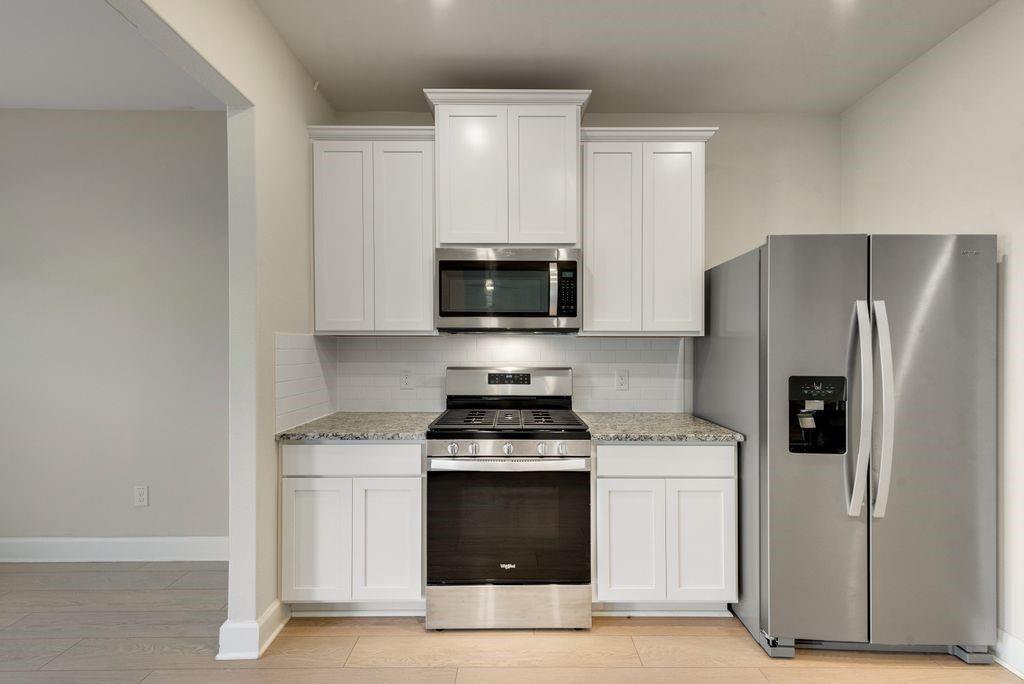 1421 Butler Avenue Princeton, TX 75407 - Photo 11 of 25 a kitchen with a stove and a refrigerator