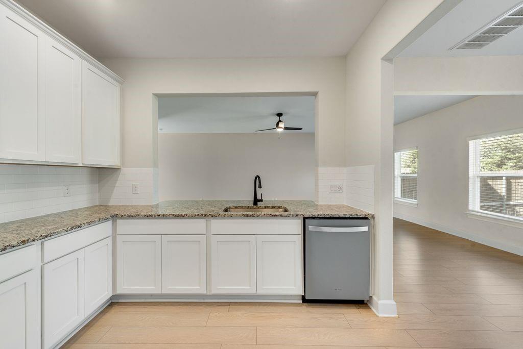 1421 Butler Avenue Princeton, TX 75407 - Photo 12 of 25 a kitchen with stainless steel appliances granite countertop a sink and cabinets with wooden floor