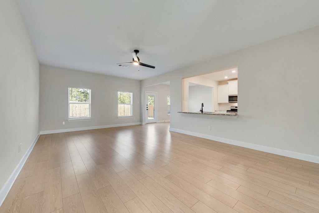 1421 Butler Avenue Princeton, TX 75407 - Photo 7 of 25 a view of an empty room with window and wooden floor