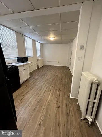 a view of a kitchen with wooden floor and electronic appliances