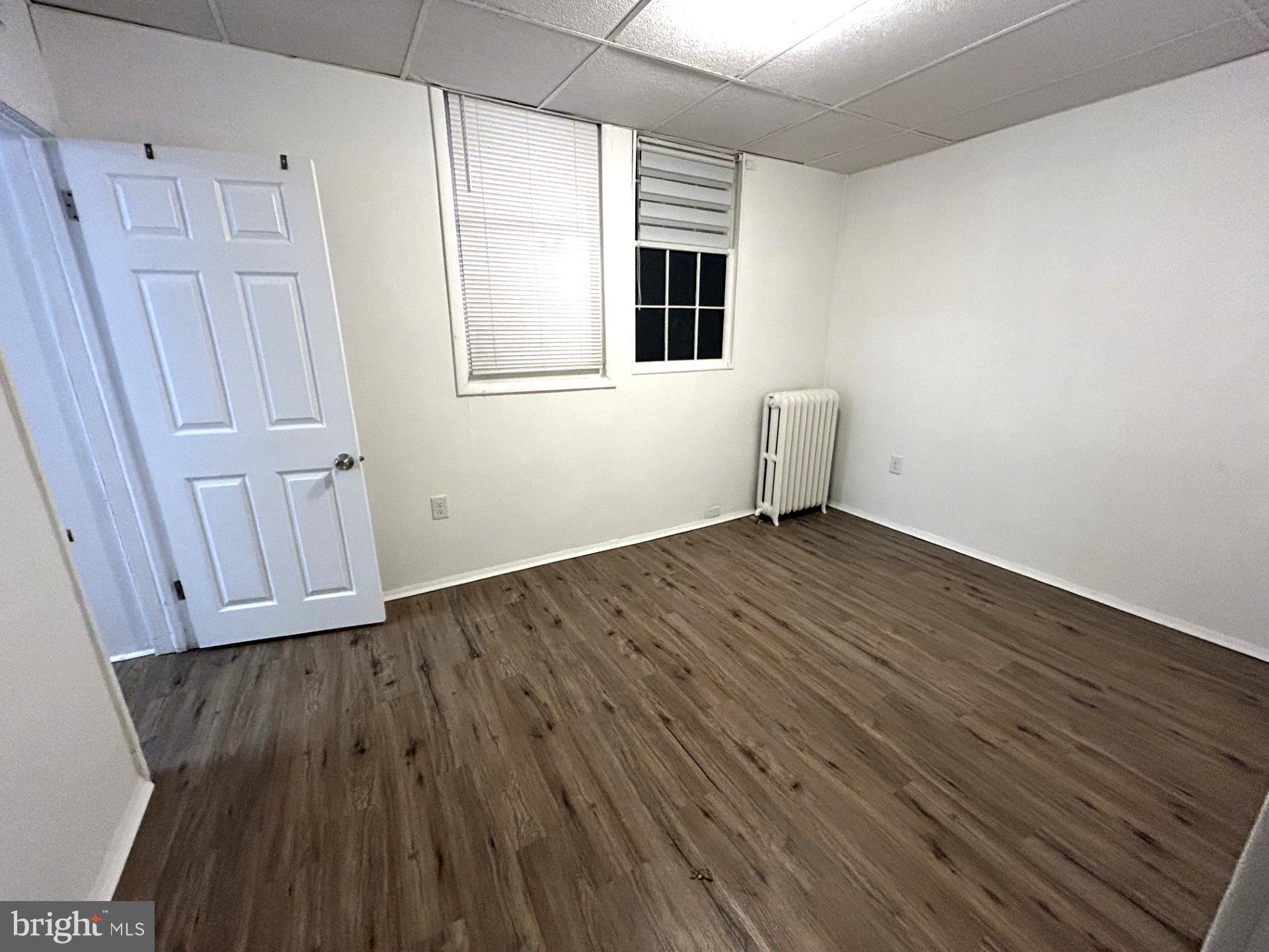 435 Radcliffe Street, Unit 13 Bristol, PA 19007 - Photo 6 of 8 an empty room with wooden floor and windows