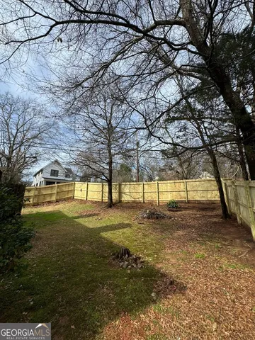 a view of a yard with wooden fence