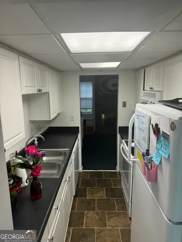 a kitchen with granite countertop lots of clutter and stainless steel appliances