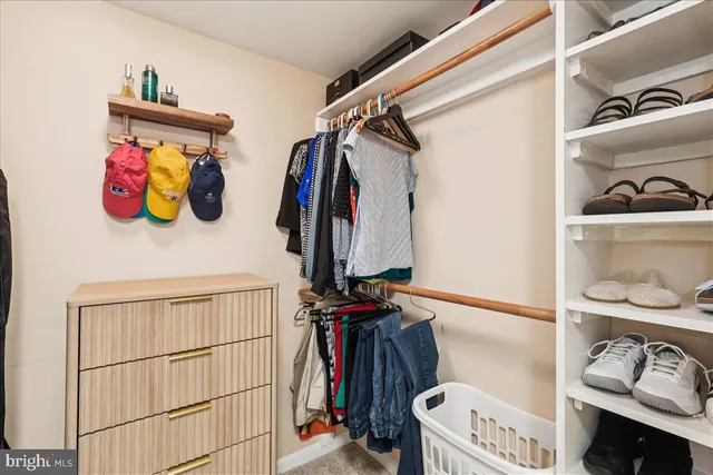 a view of walk in closet with clothes and shoes