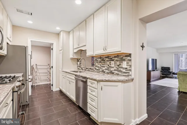 a kitchen with stainless steel appliances granite countertop a stove and a refrigerator