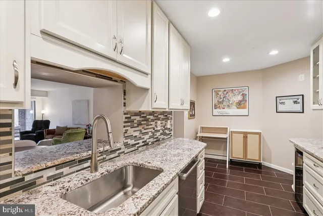 a kitchen with stainless steel appliances granite countertop a sink and a stove top oven