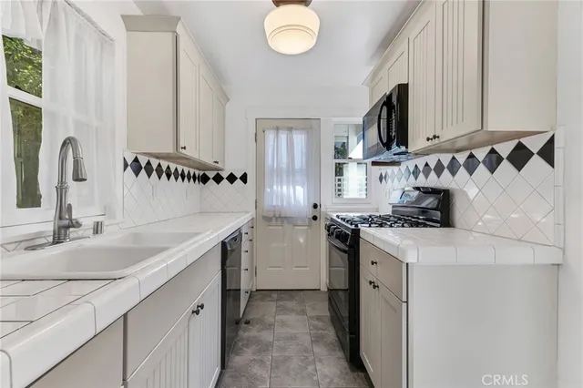 a kitchen with stainless steel appliances granite countertop a sink and a stove